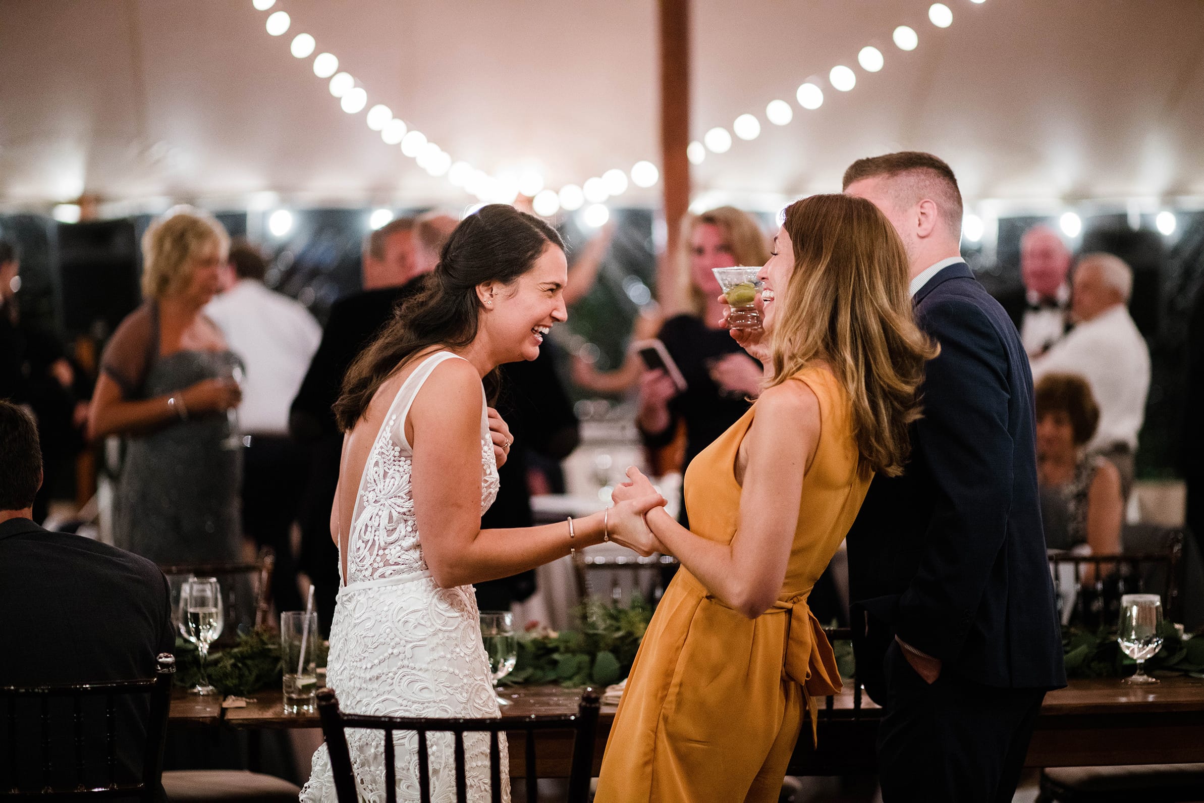 A best of Boston Wedding Photograph of a bride talking and laughing with guests during her Willowdale estate wedding