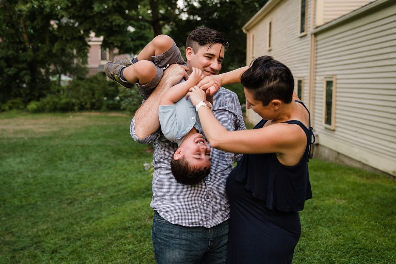 A best of Boston family photograph of a mom and dad tickling their son during an in home family session in Boston