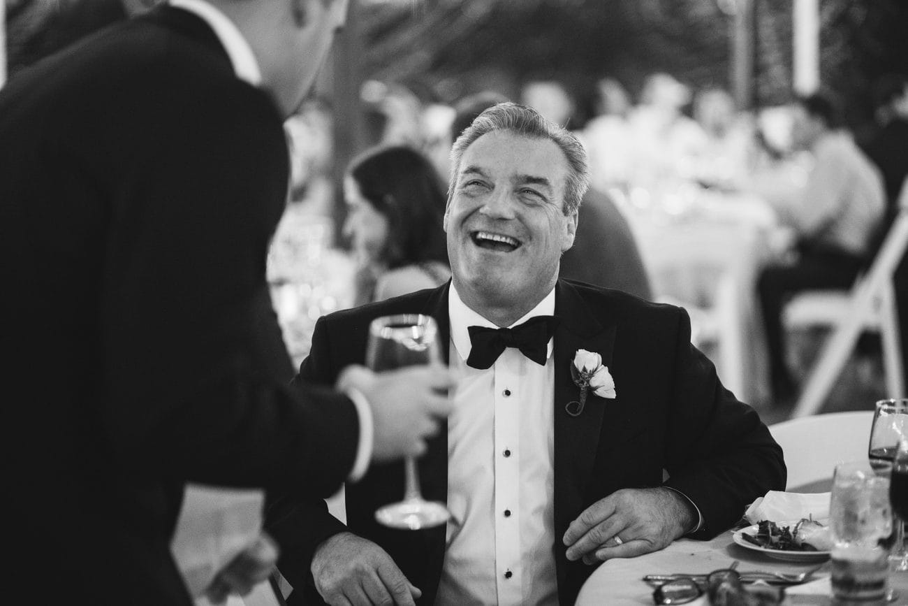 A best of Boston wedding photograph of a father of the bride laughing during a willowdale estate wedding reception