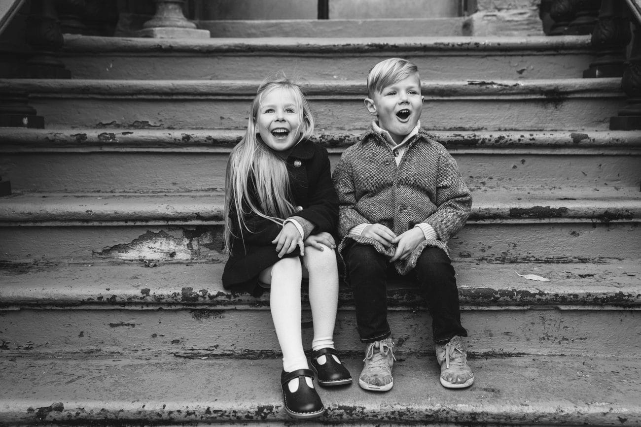 A best of Boston family photograph of a brother and sister sitting on the front steps of their house during there in home family session in the south end of Boston
