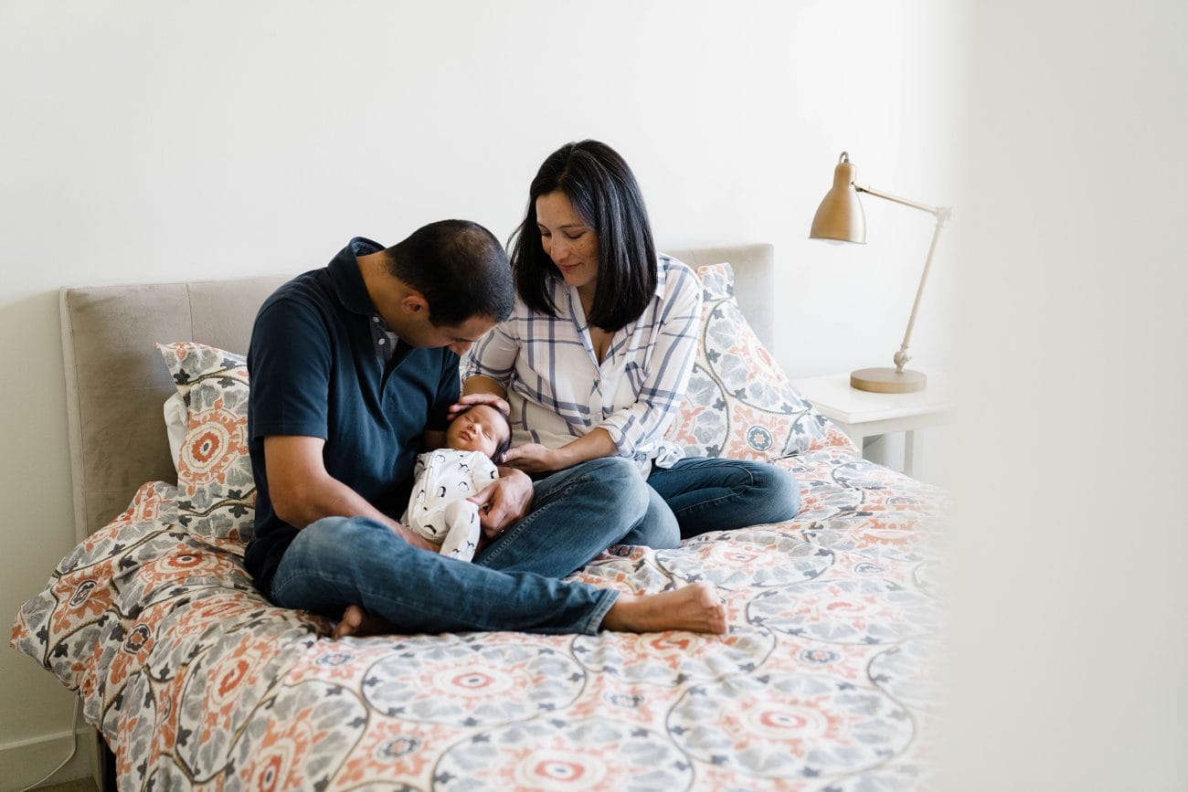 A best of Boston family photograph of parents cuddling their newborn son during an in home newborn session