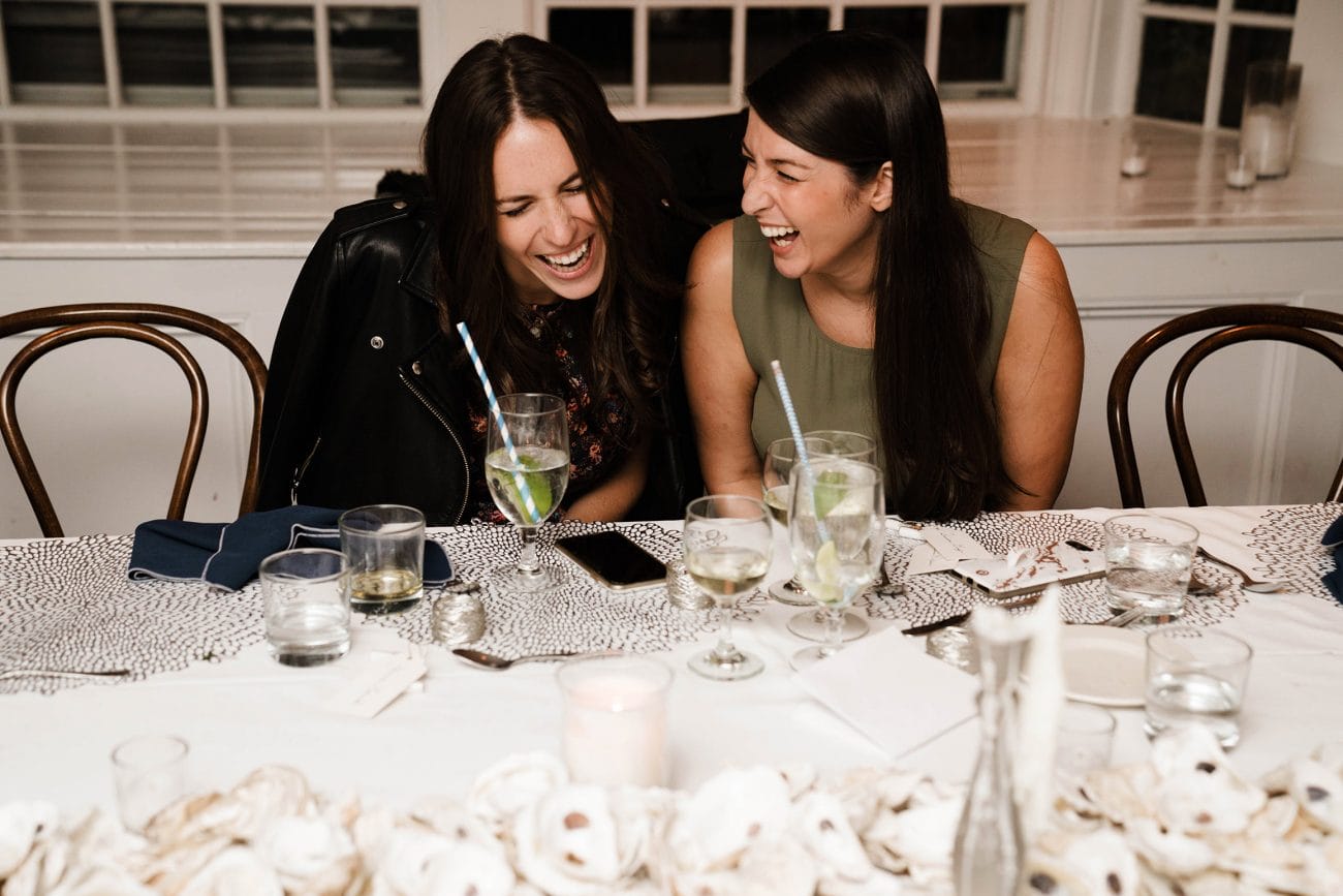 A best of Boston wedding photograph of two girls laughing during a wedding rehearsal dinner in Boston