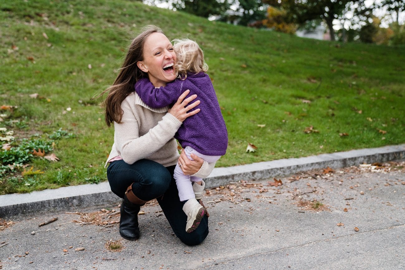 A best of Boston family photograph of a mom hugging her daughter during their lifestyle family session at Jamaica Pond