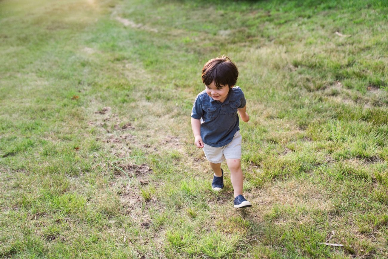 A best of Boston family photograph of a boy running in the grass during their lifestyle family session in Boston