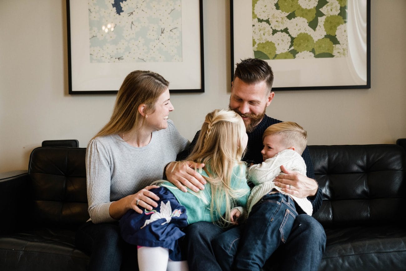 A best of Boston family photograph of a family laughing and cuddling on the couch during their in home family session in the South End of Boston