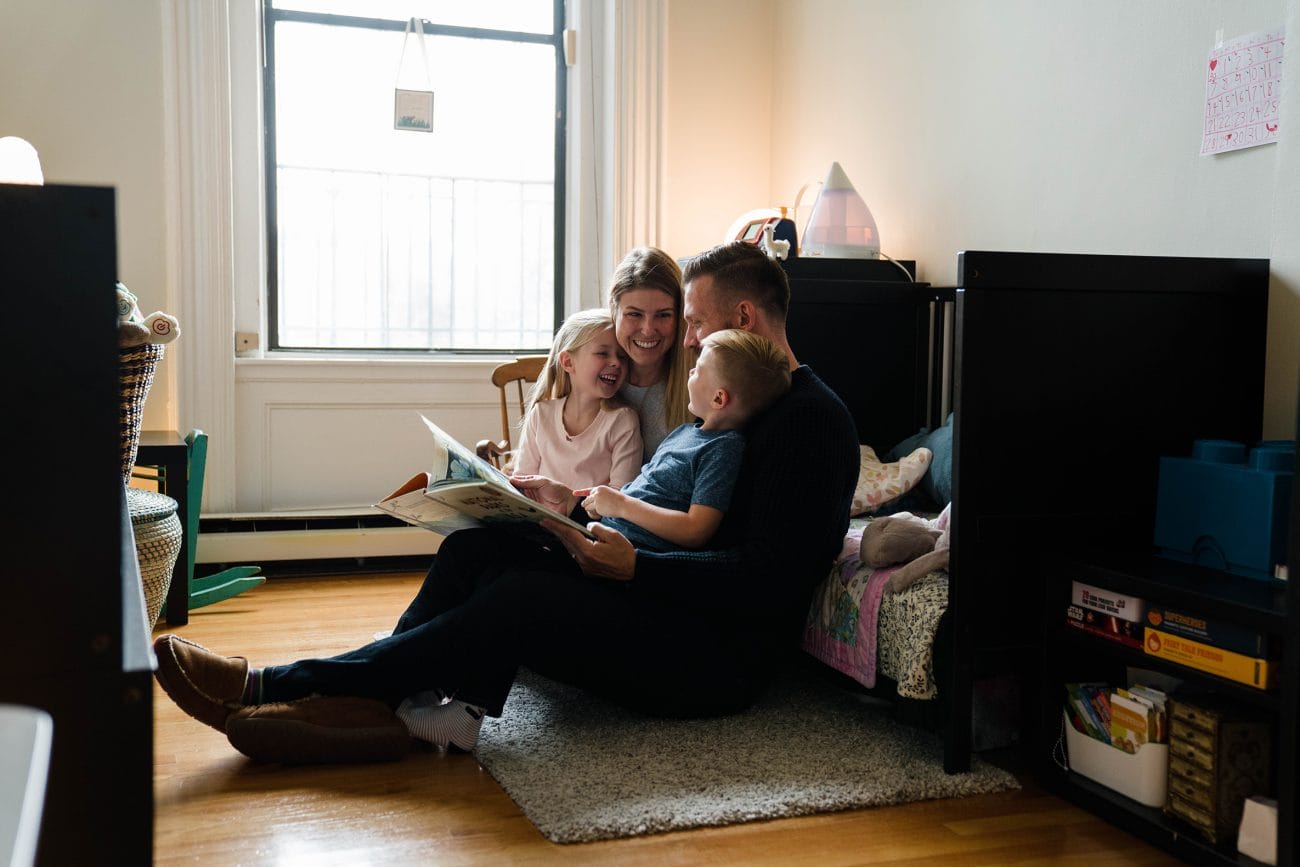 A best of Boston family photograph of a family reading a book together during their in home family session in the South End of Boston