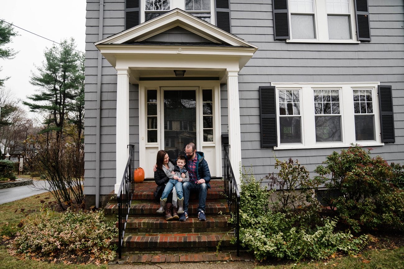 A best of Boston family photograph of a family sitting on their porch during an in home family session in Boston