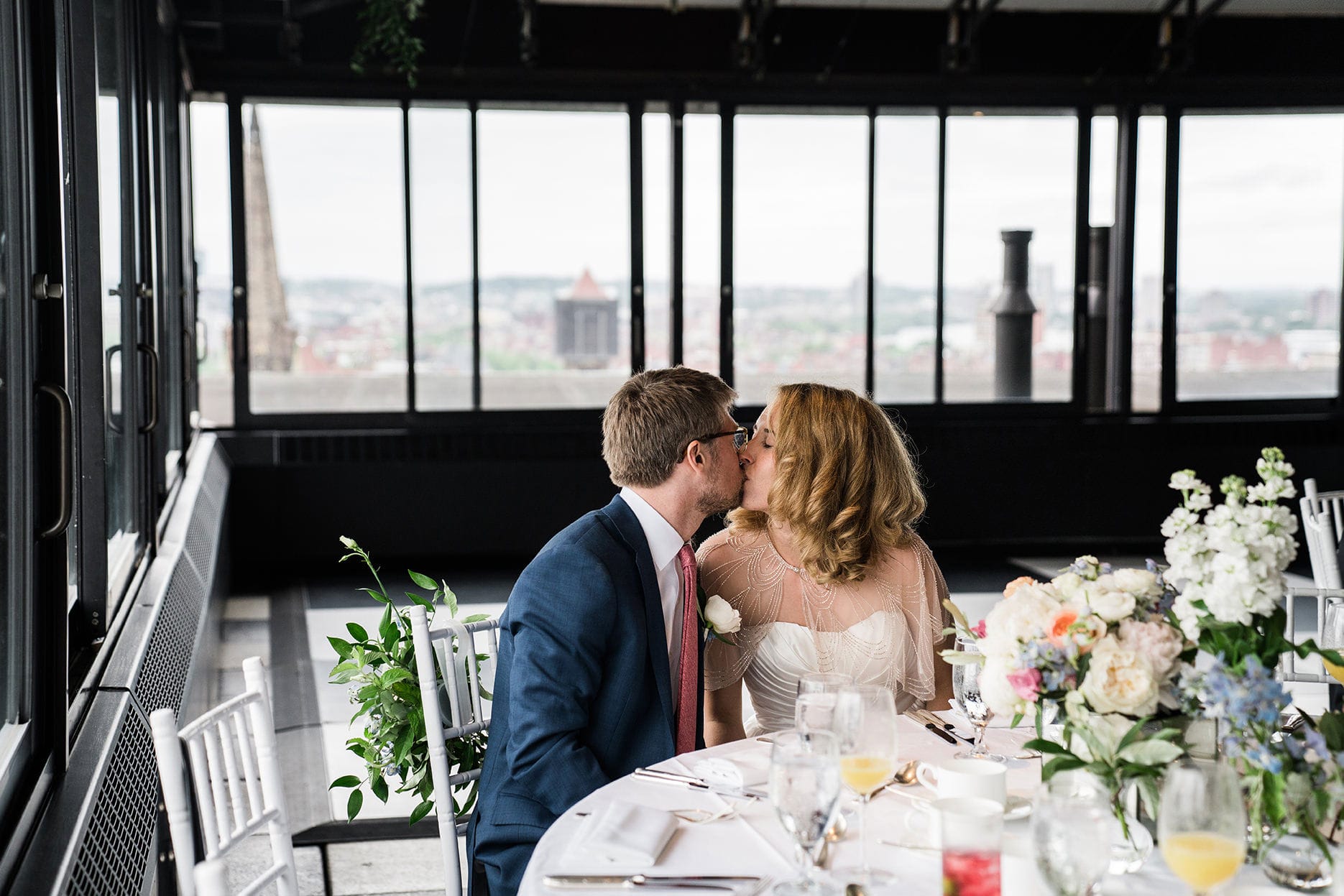 A best of Boston wedding photograph of a couple kissing their Taj Boston Rooftop wedding reception