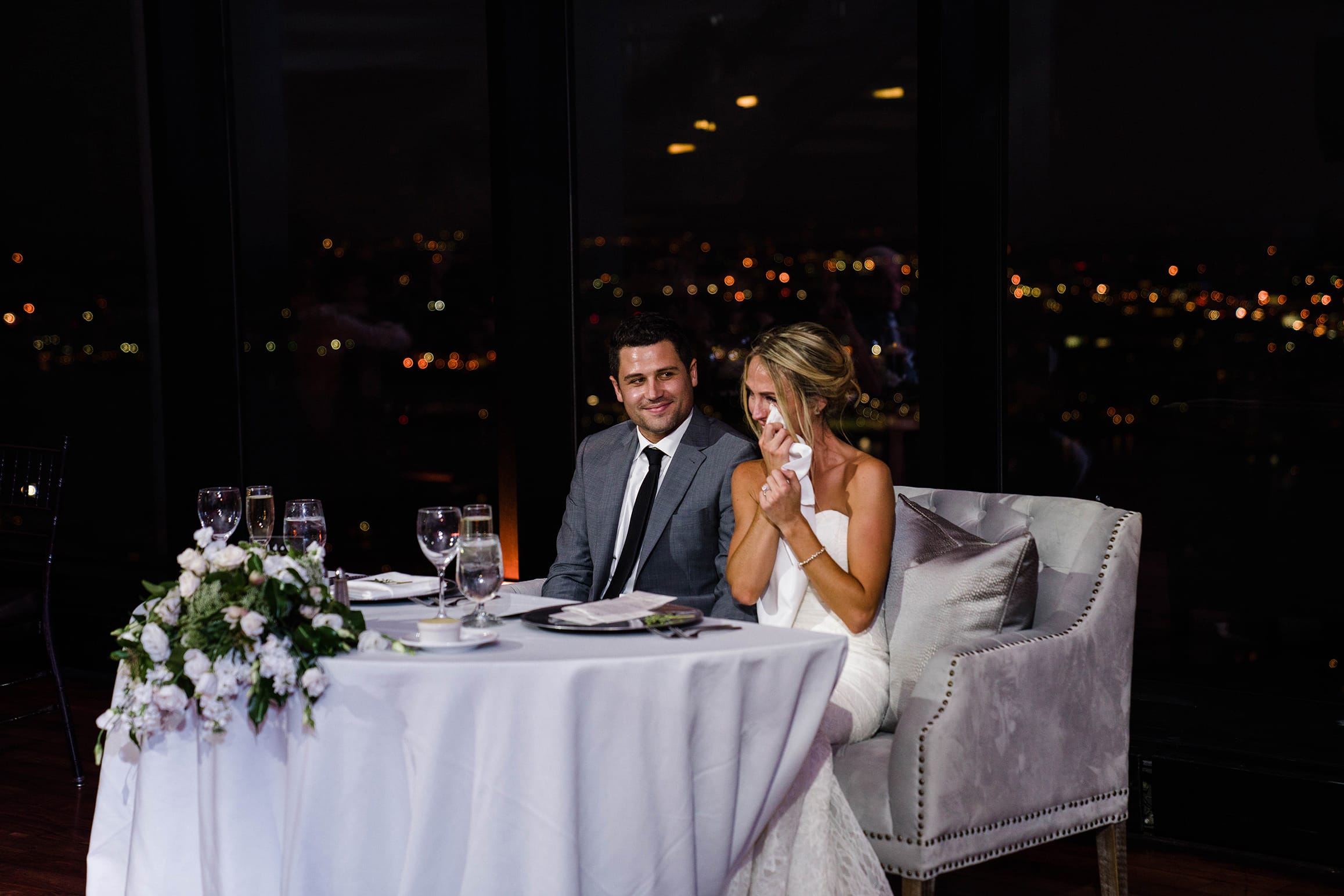 A best of Boston wedding photograph of a bride wiping tear during the wedding toasts at her State Room wedding