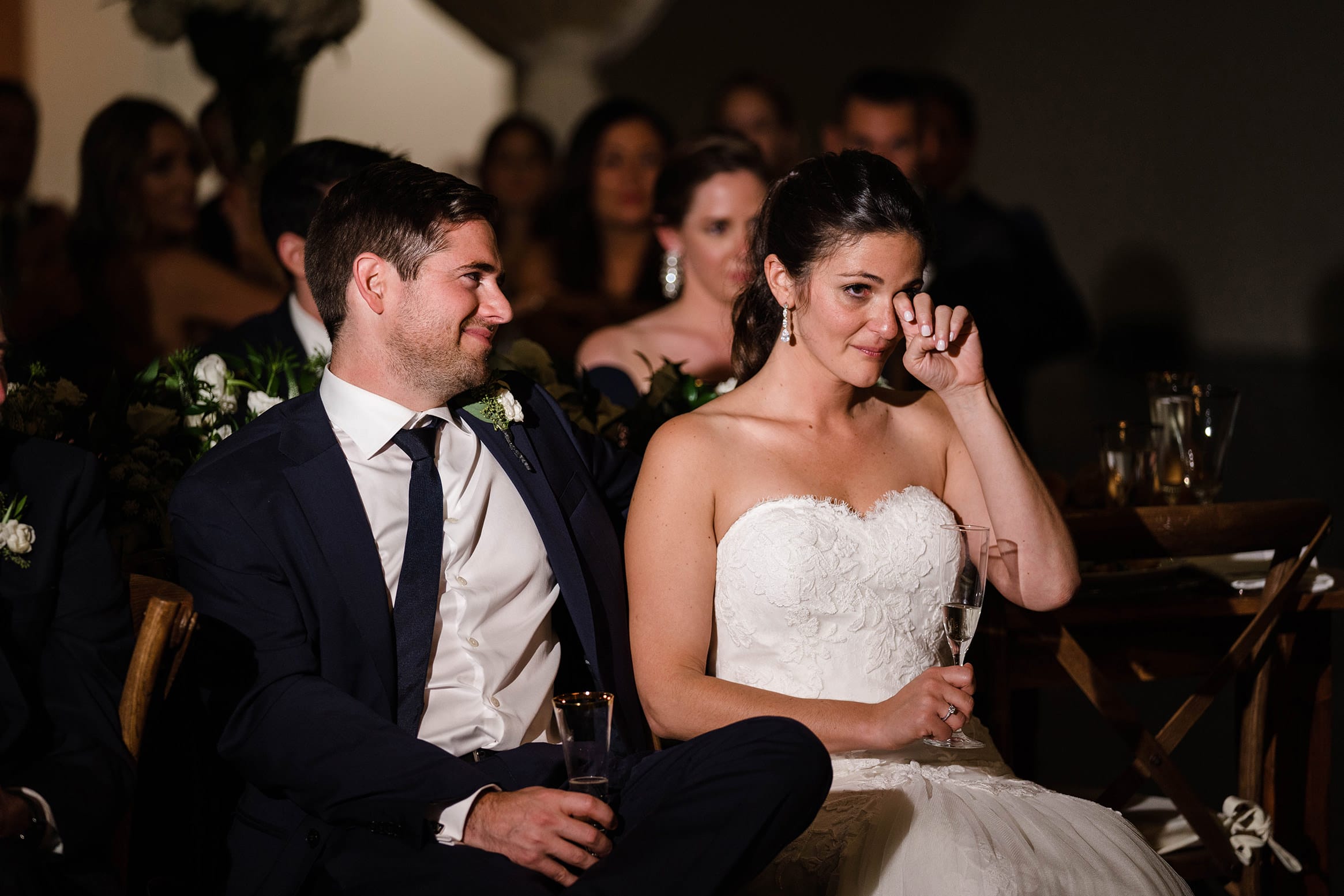 A best of Boston Wedding photograph of a bride wiping away a tear during the wedding toast at her Cyclorama wedding 
