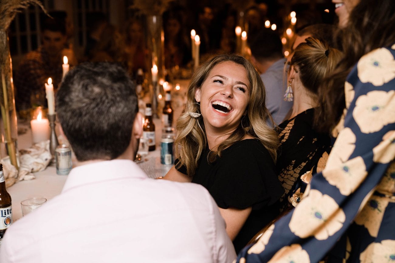 A best of Boston wedding photograph of guests laughing during a wedding rehearsal dinner in Boston