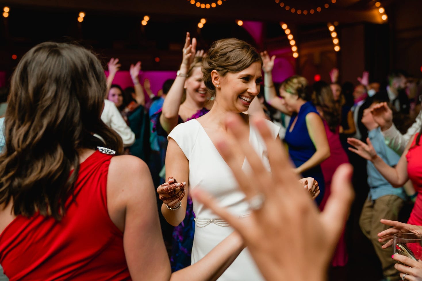 A best of Boston wedding photograph of a bride dancing with friends during an Indian American wedding in Providence, RI