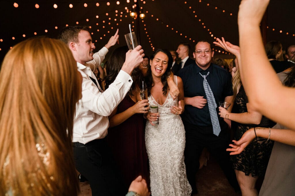 A documentary photograph of a wedding couple dancing with their guests at a Willowdale Estate Wedding. 
