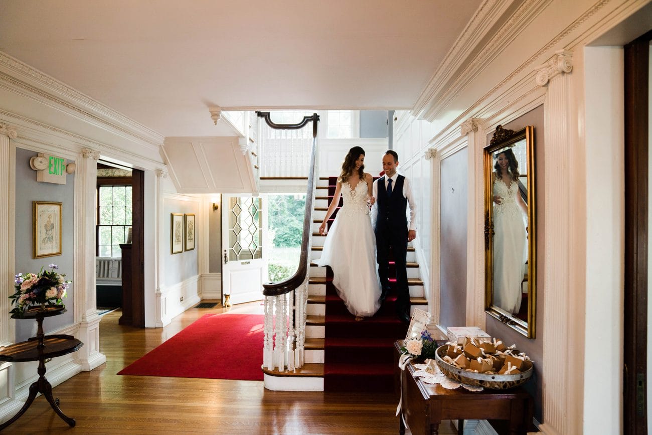 A documentary photograph featured in the best of wedding photography of 2019 showing a bride and groom walking downstairs together
