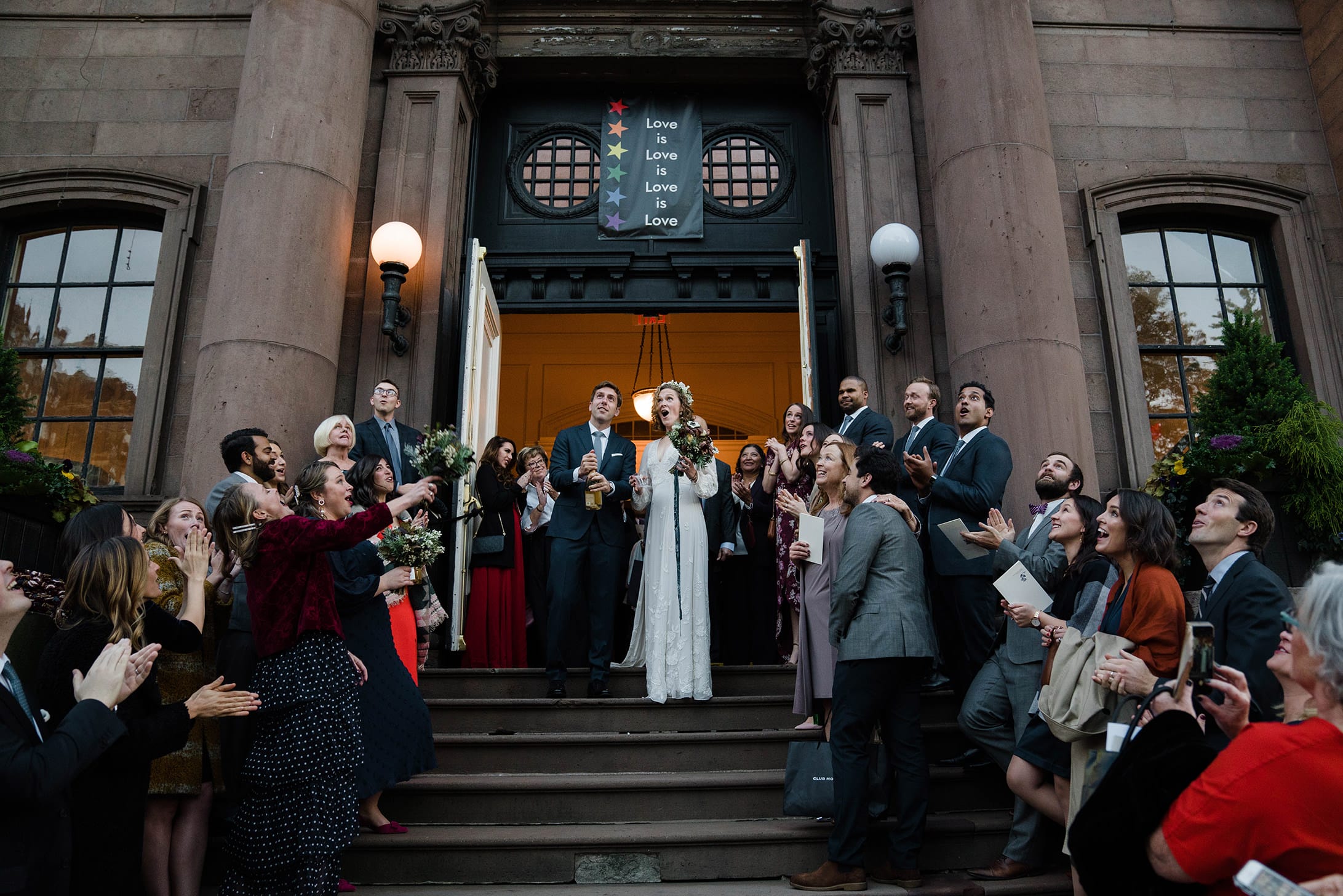 A documentary photograph featured in the best of wedding photography of 2019 showing a groom popping the Champagne after their wedding ceremony