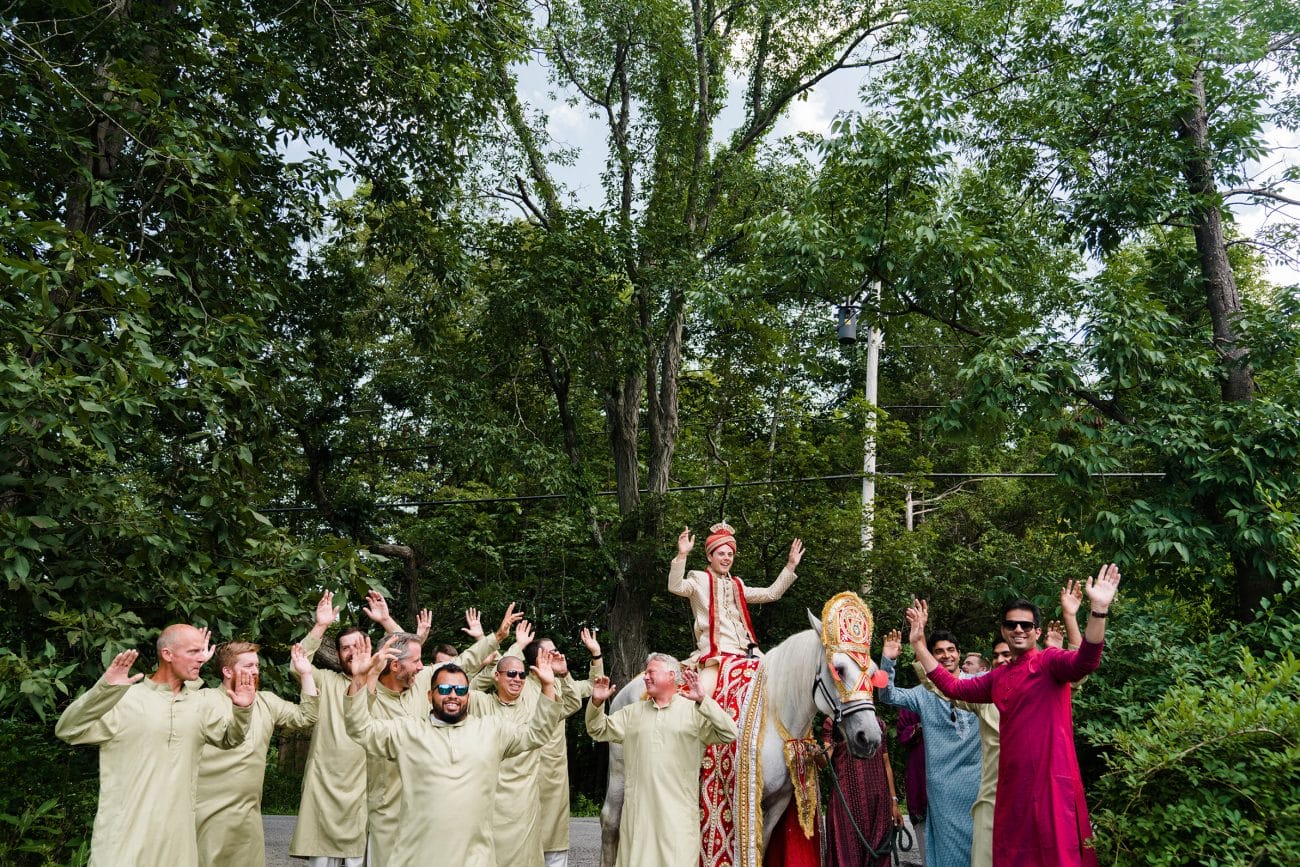 A documentary photograph featured in the best of wedding photography of 2019 showing a groom dancing on a horse during the Baraat