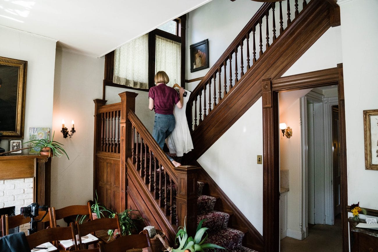 A documentary photograph featured in the best of wedding photography of 2019 showing a bride walking up the stairs with her wedding dress