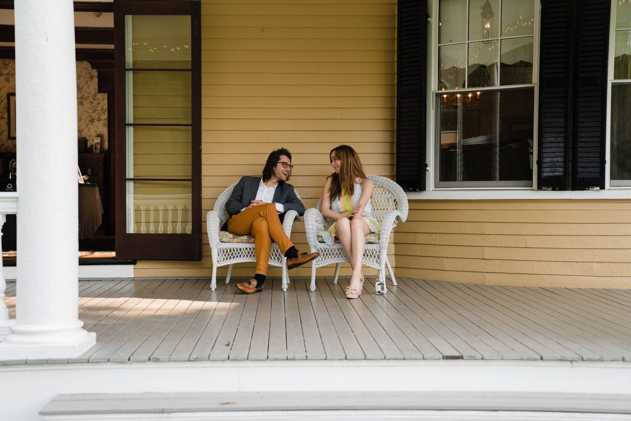 A documentary photograph featured in the best of wedding photography of 2019 showing a couple hanging out the porch of pierce house