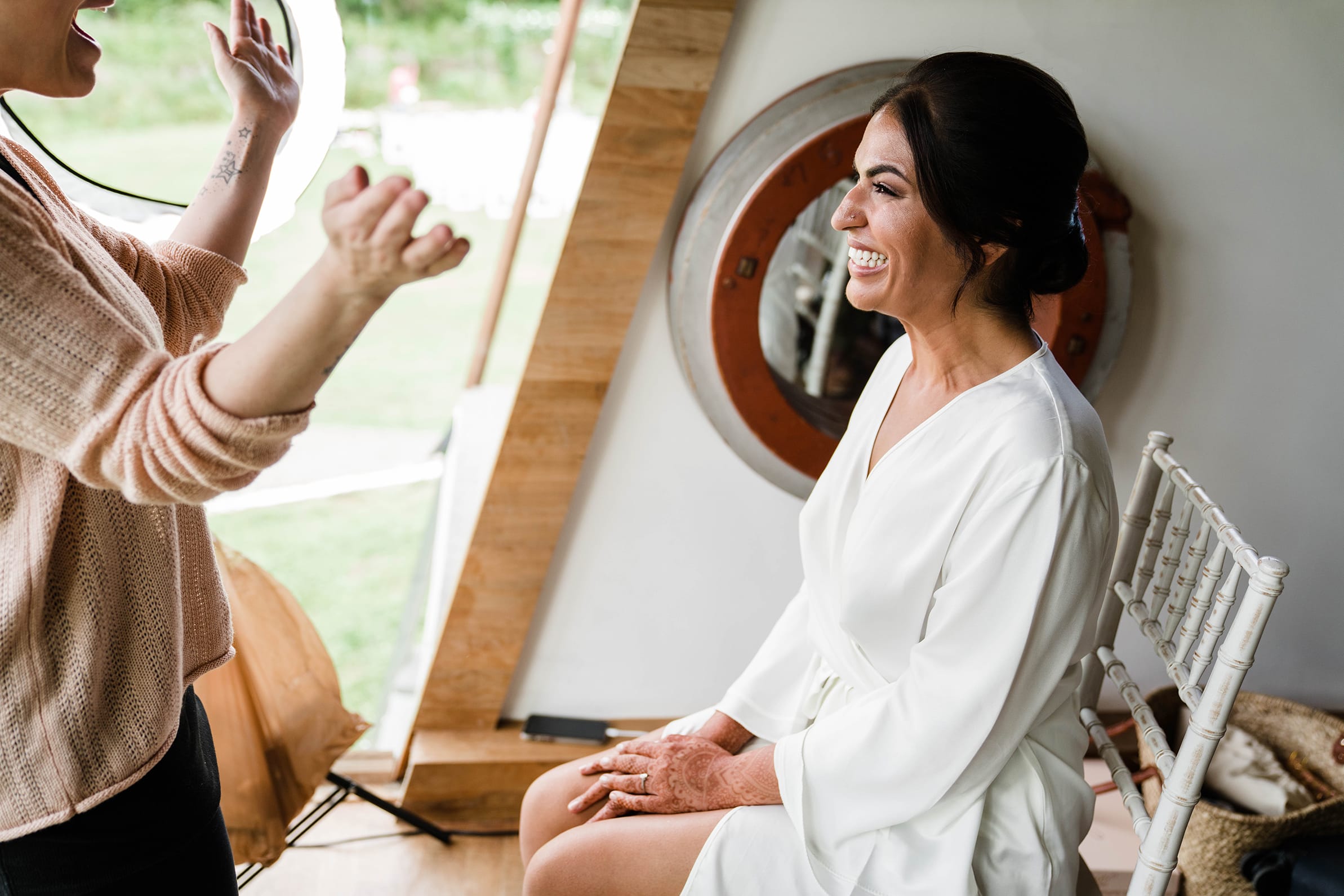 A documentary photograph featured in the best of wedding photography of 2019 showing a bride and friend getting excited for the wedding while getting ready