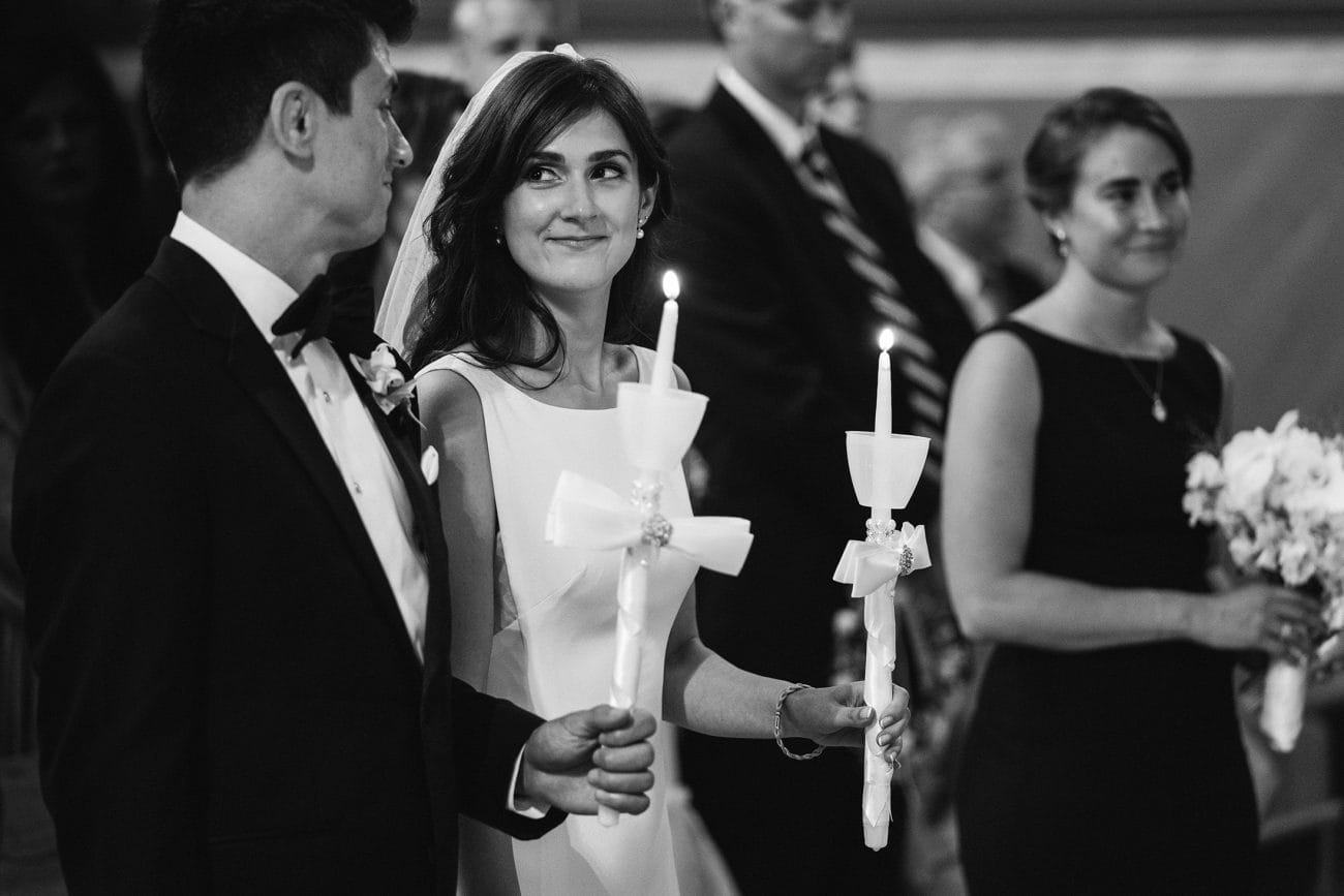 A documentary photograph featured in the best of wedding photography of 2019 showing a bride smiling during her greek wedding ceremony