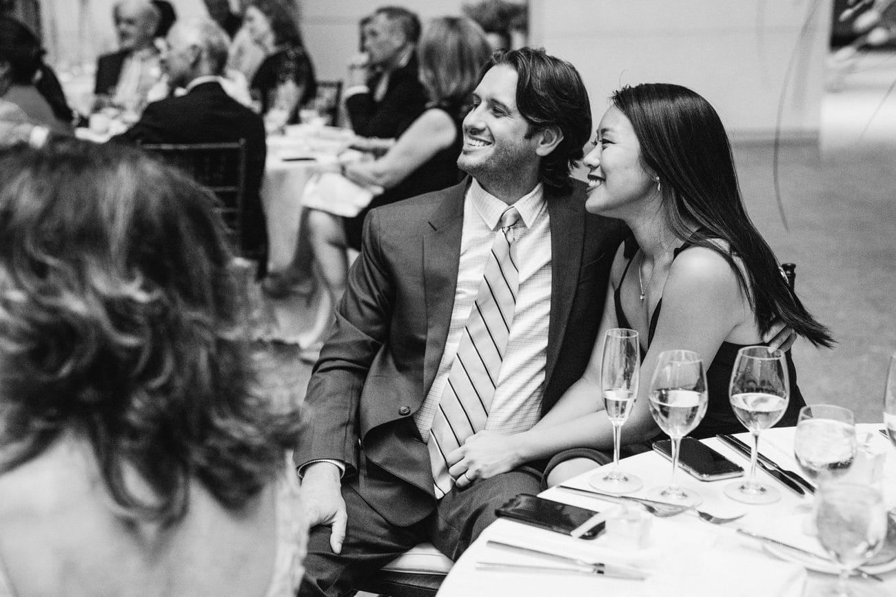 A documentary photograph featured in the best of wedding photography of 2019 showing a couple smiling during the wedding toasts