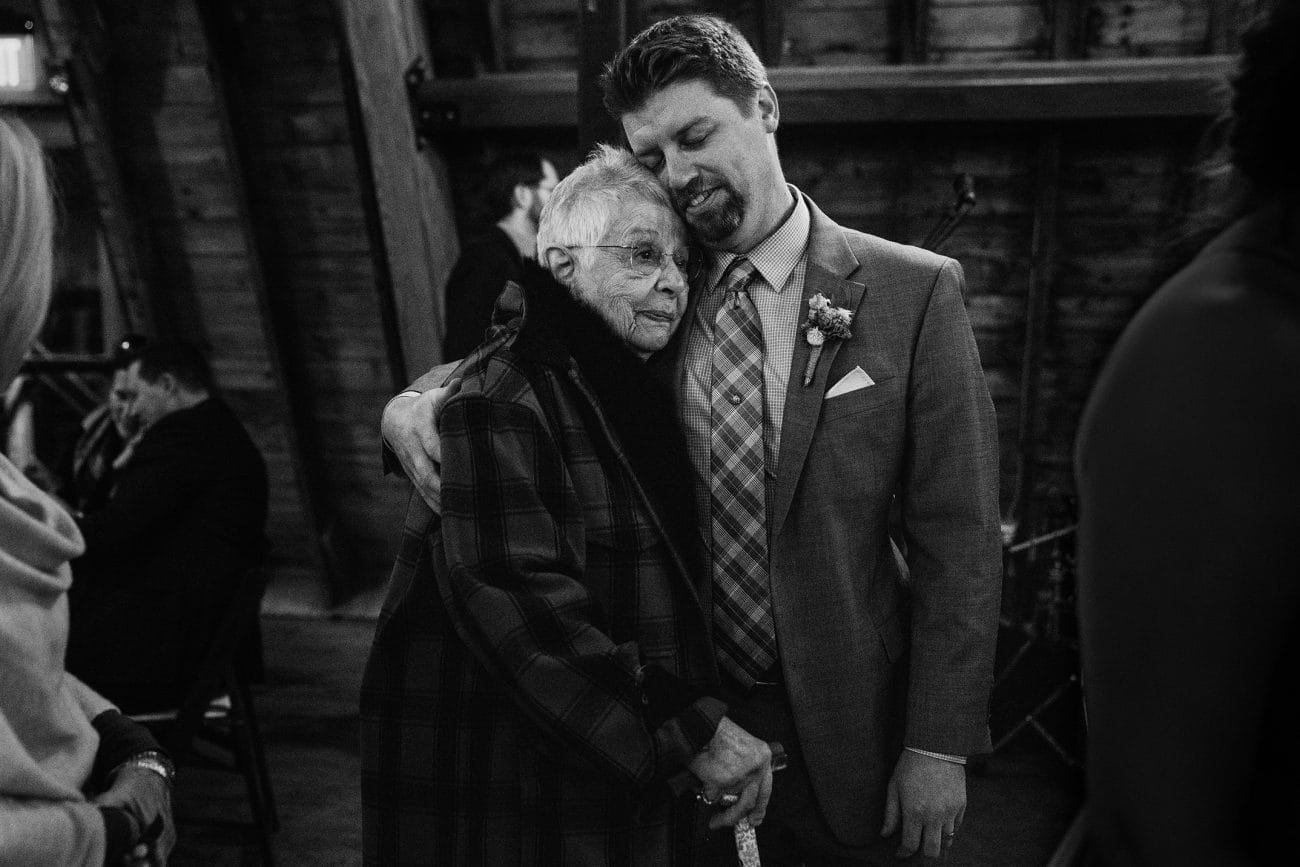 A documentary photograph featured in the best of wedding photography of 2019 showing a groom hugging his grandma