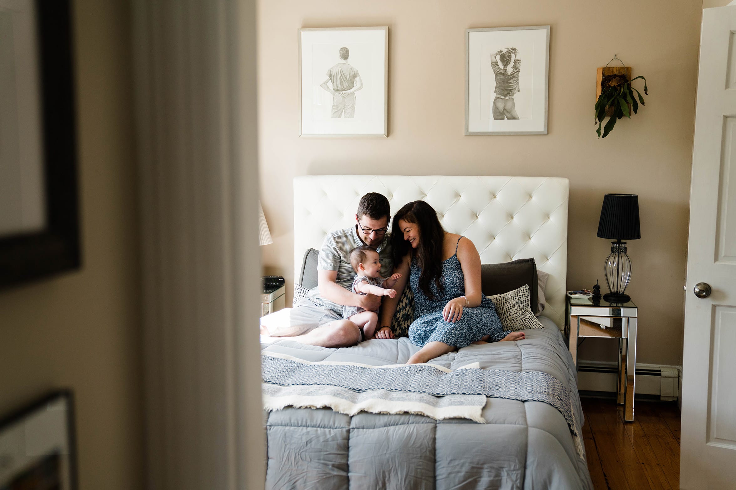 A documentary photo of family cuddling in bed during an in home family session in Boston