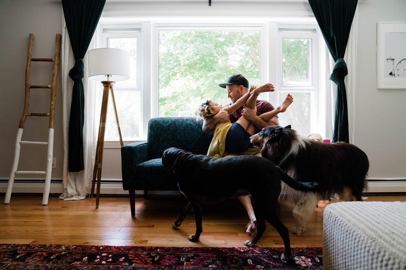 A documentary photograph of a dad playing with his daughter during an in home family session in Boston