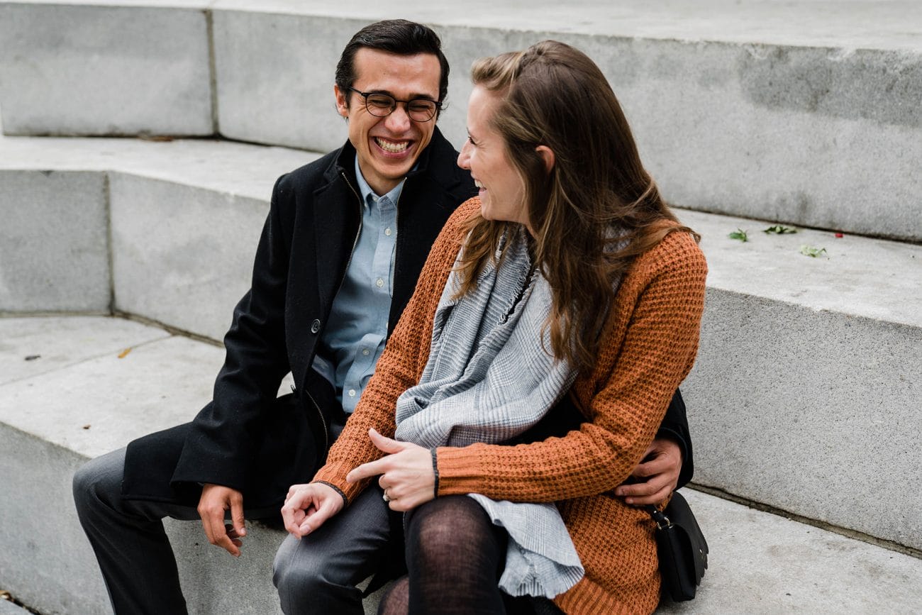 A documentary photograph of a couple laughing during a date night engagement session in Boston