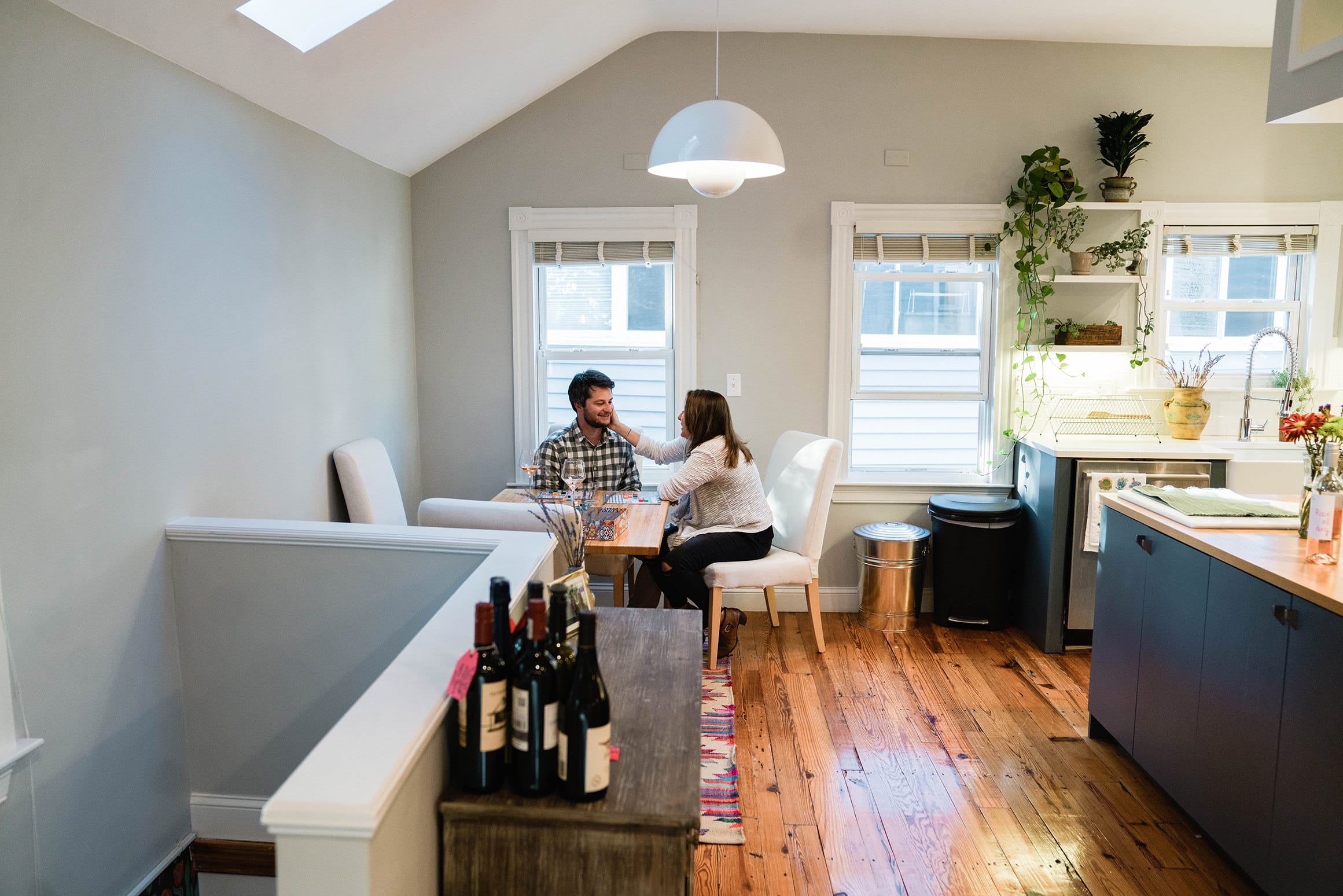 A documentary photograph of a couple sitting at the table together during their in home engagement session in Boston