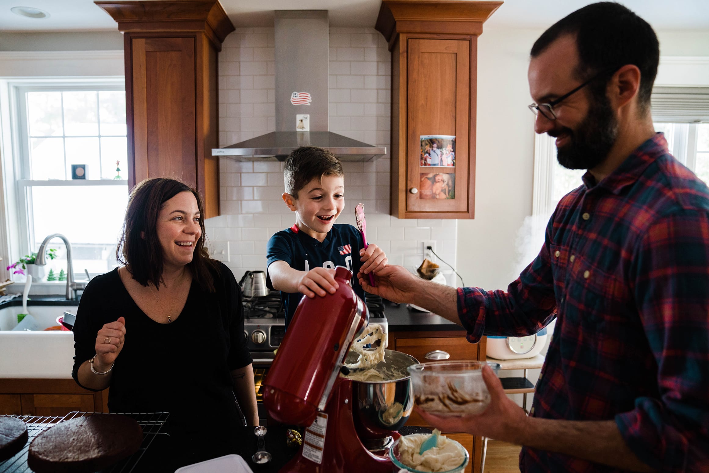A best of Boston family photograph of family making a birthday cake together during an in home family session in Boston