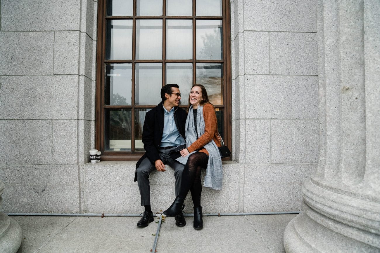 A documentary photograph of a couple laughing together at the Museum of Fine Arts Boston during their date night engagement session