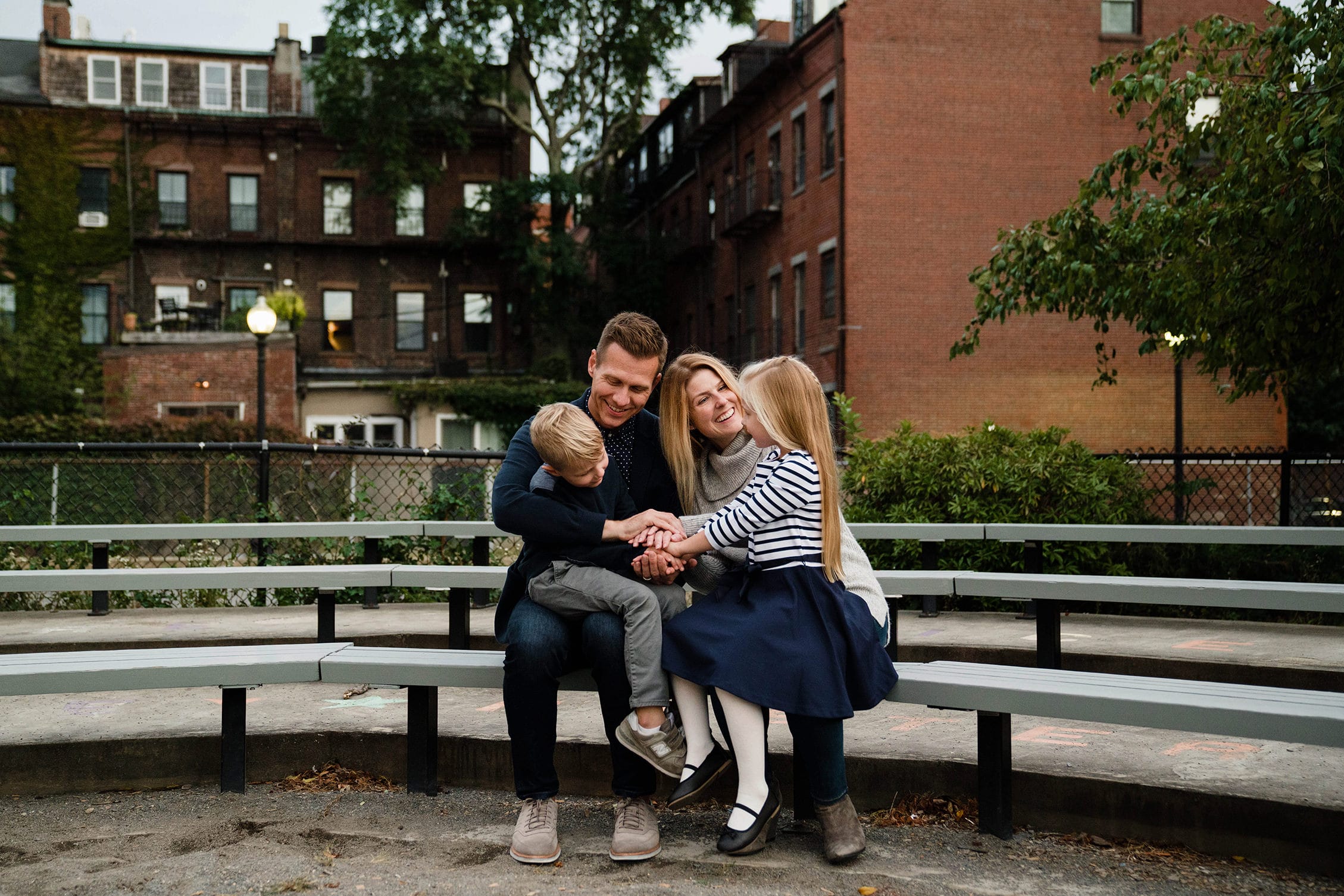 A best of Boston photograph of a family hanging out at the playground during a day in life family session in Boston