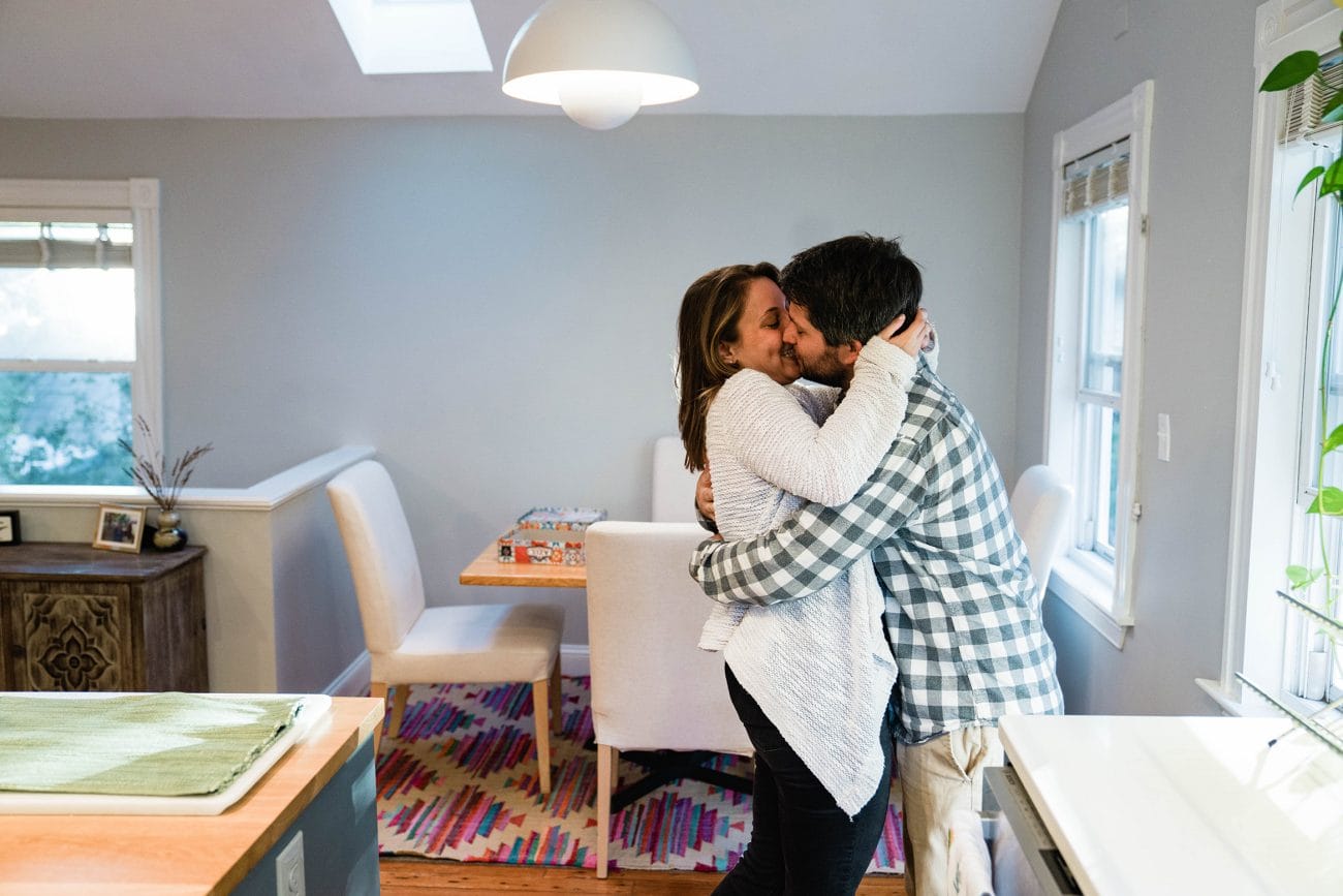 A best of Boston engagement photograph of a couple kissing in their kitchen during an in home Boston engagement session