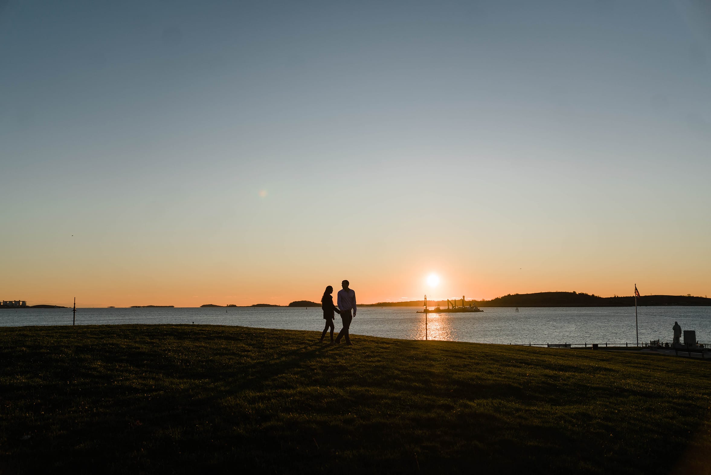 A documentary photograph of a couple walking together during their sunrise engagement session in Boston