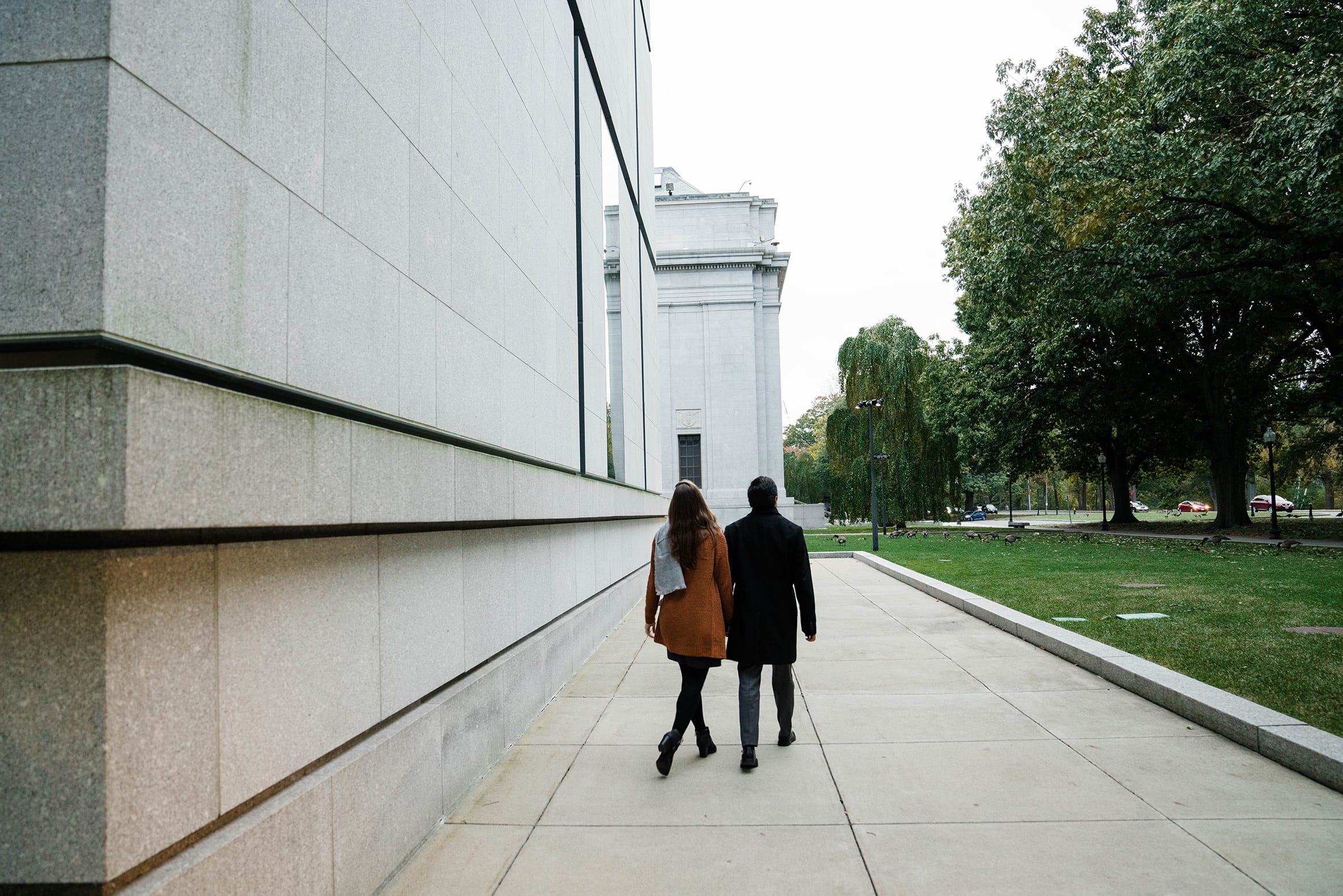 A best of Boston engagement photograph of couple walking by the Boston Museum of Fine Arts during their date night engagement session