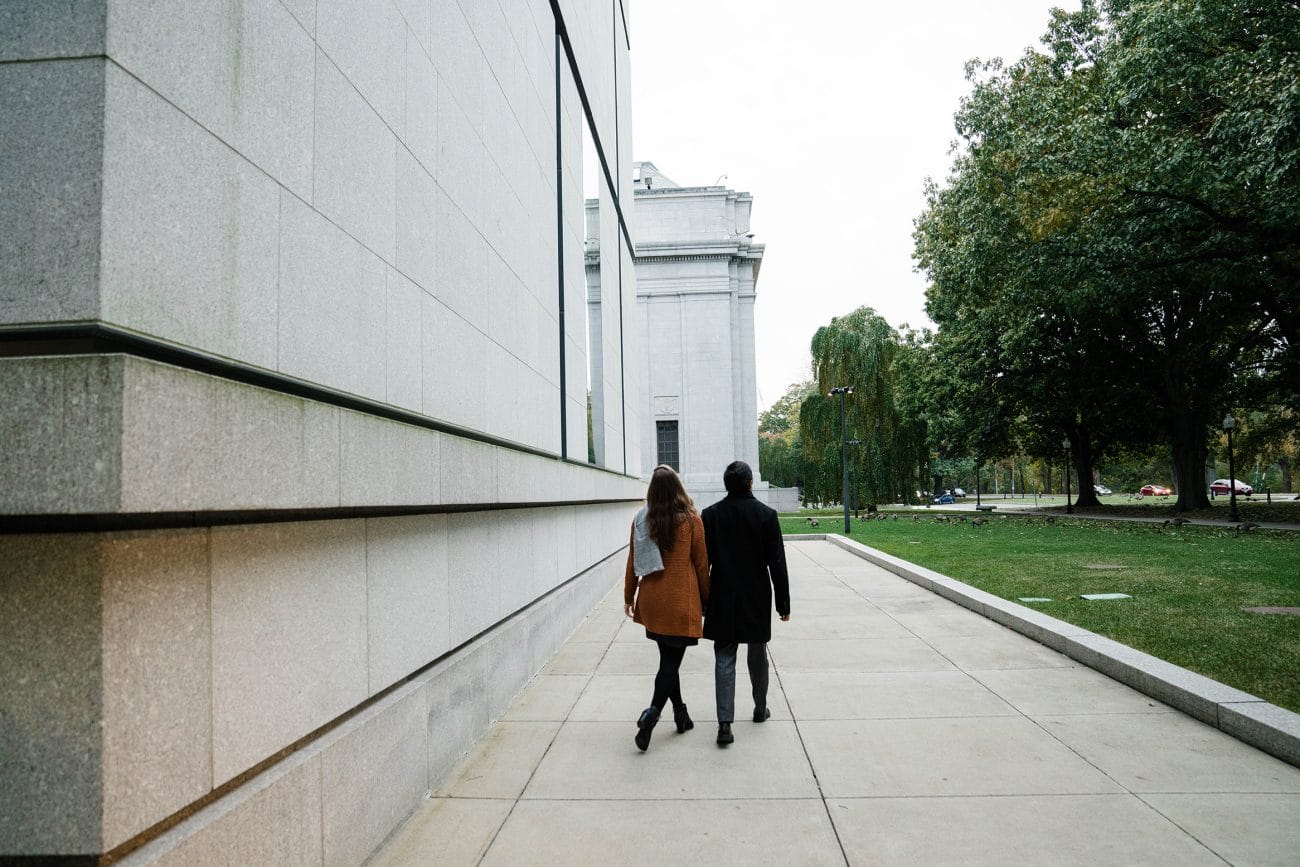 A best of Boston engagement photograph of couple walking by the Boston Museum of Fine Arts during their date night engagement session