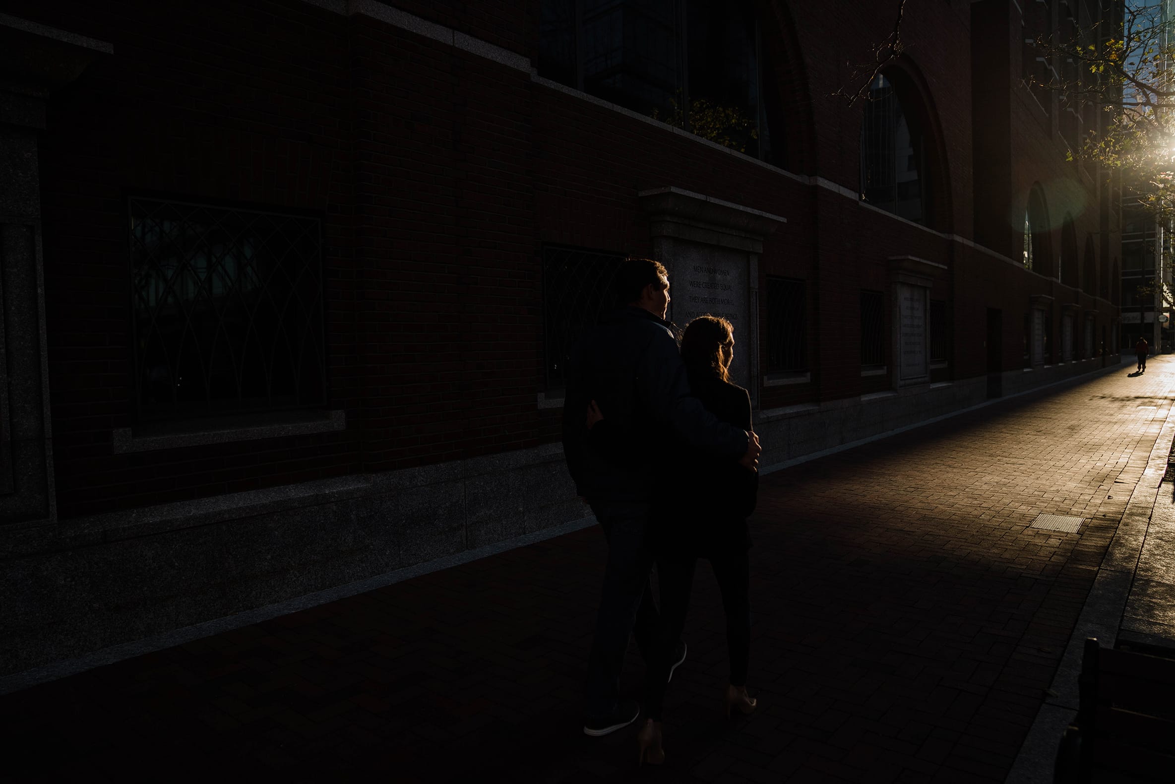 A documentary photograph of a couple walking down the street during their sunrise engagement session