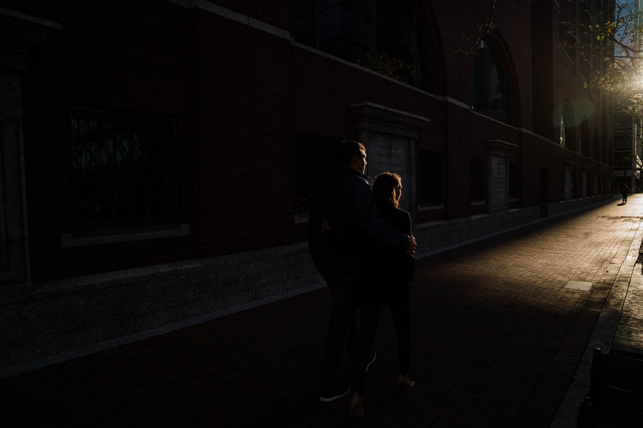 A documentary photograph of a couple walking down the street during their sunrise engagement session
