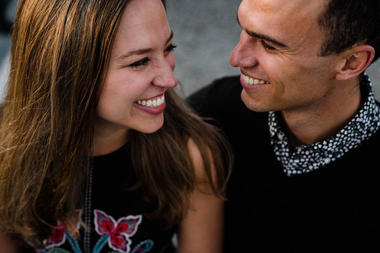 A documentary portrait of couple smiling at each other during their date night engagement session in Boston