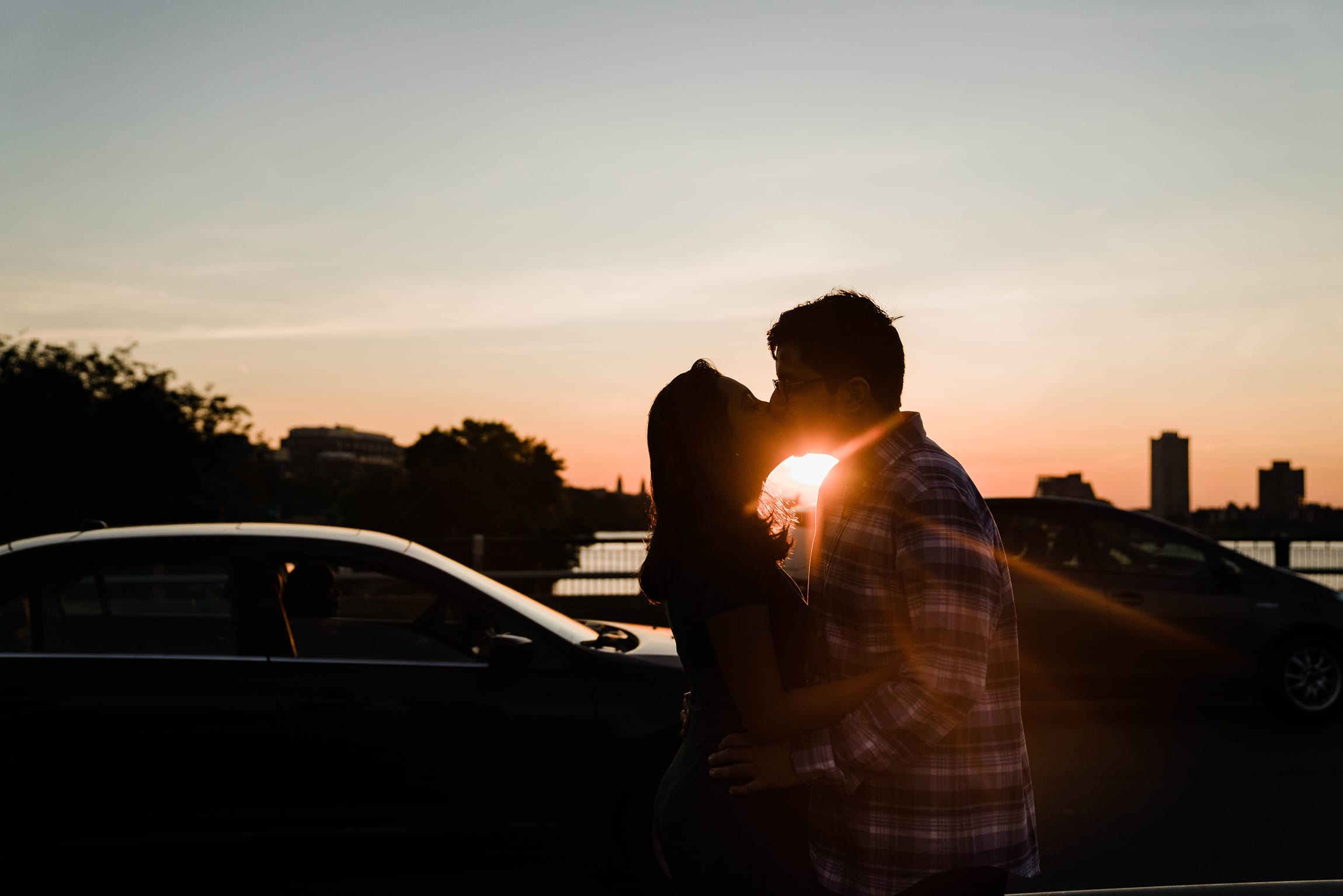 A best of Boston engagement photograph of a couple kissing on the  Charles River bridge during a date night engagement session