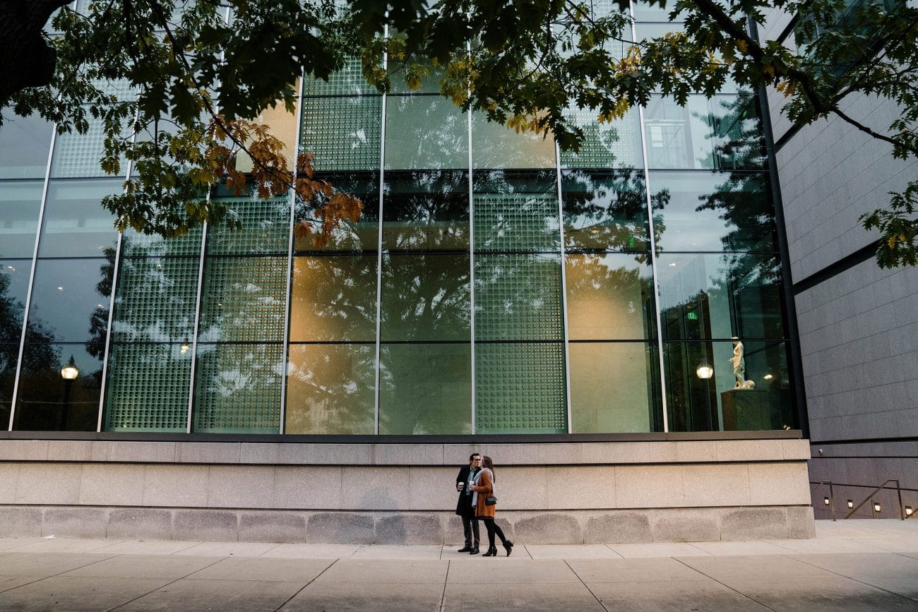 A best of Boston photograph of a couple kissing as they pass the Boston Museum Fine Arts Boston during their date night engagement session