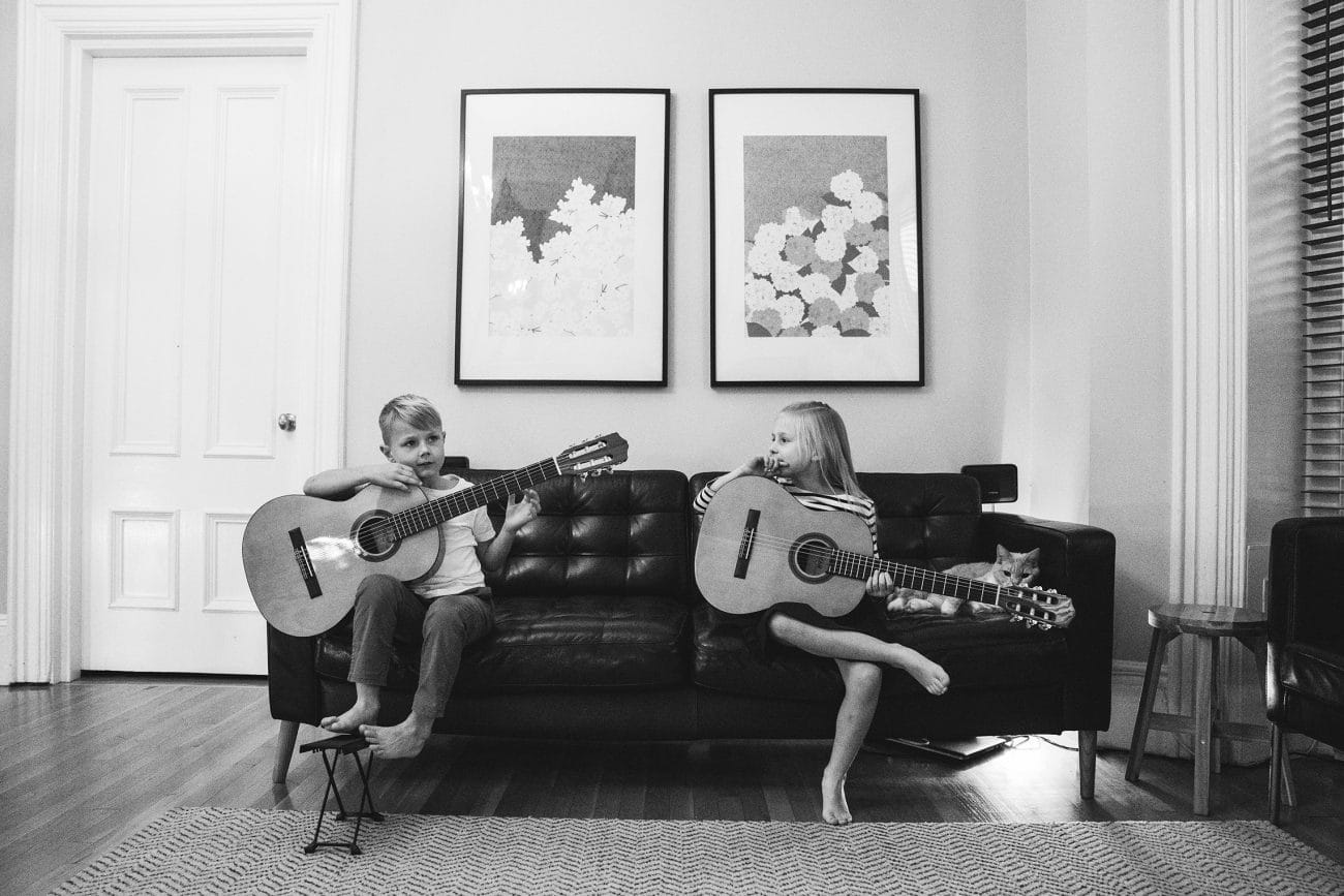 A documentary photograph of a brother and sister with their guitars during an in home family session in Boston