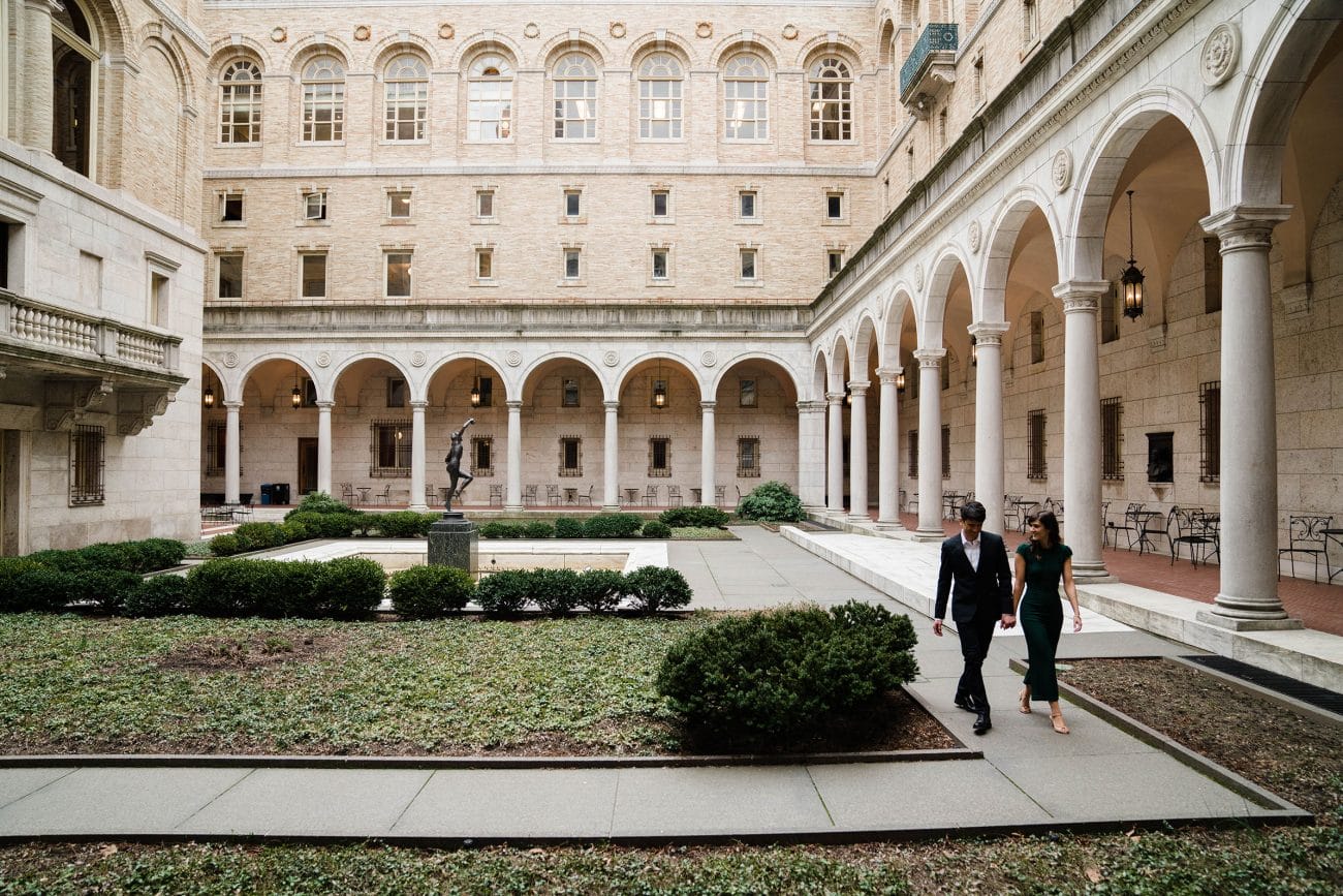 A best of Boston Engagement photograph of a couple walking together in the courtyard of the Boston public library