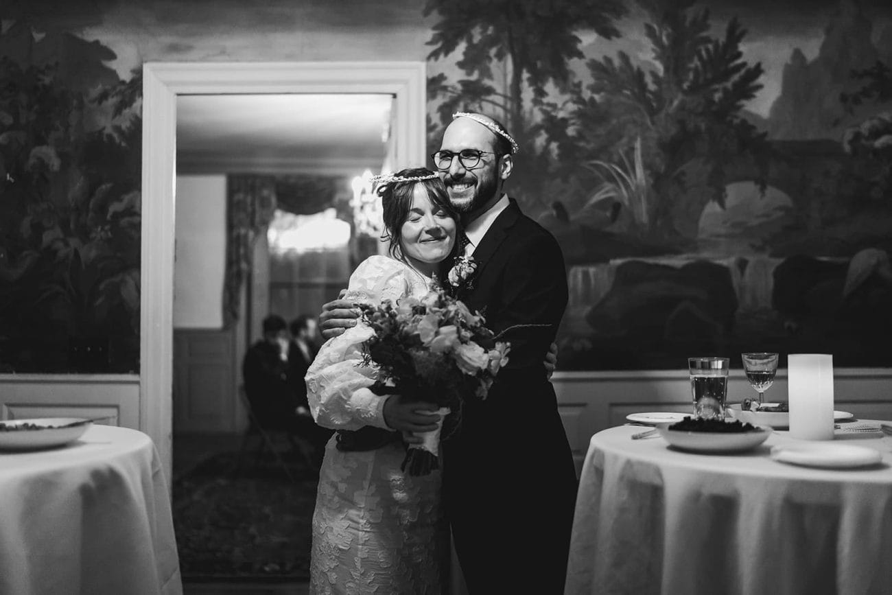 A documentary photograph of bride and groom hugging during their Loring Greenough House Wedding.  