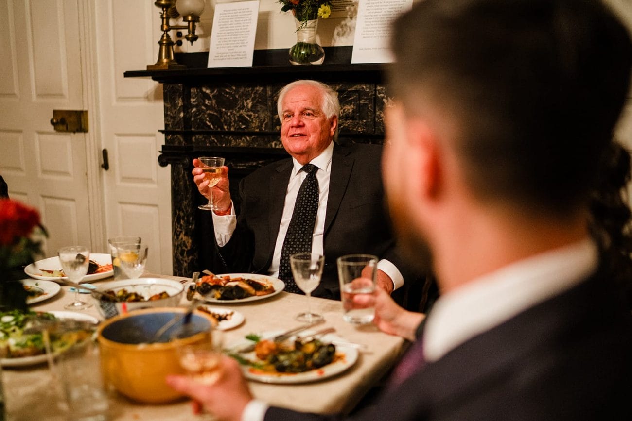 A documentary photograph of the bride's father making a toast during the dinner portion of their Loring Greenough House Wedding.  