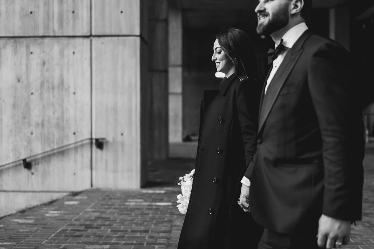 A documentary photograph of a bride and groom leaving Boston City Hall before their wedding celebration at Mooo.... Seaport.