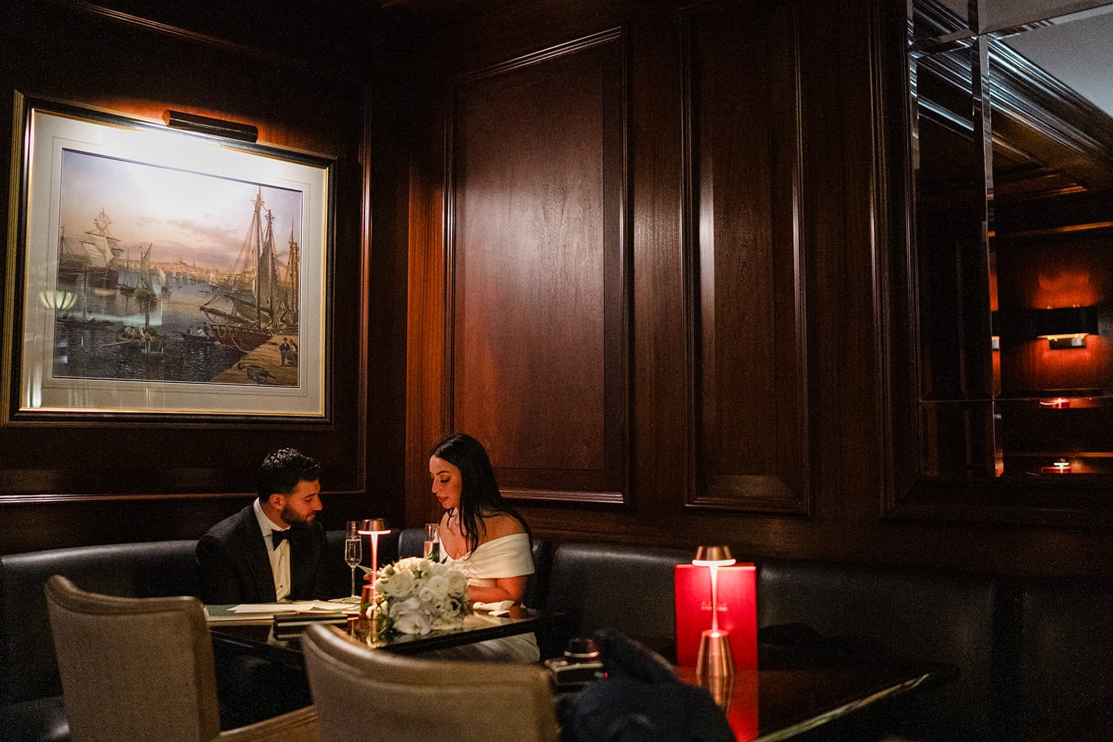 A documentary photograph of a bride and groom reading private vows at The Dark Bar before their intimate wedding at Mooo.... Seaport.