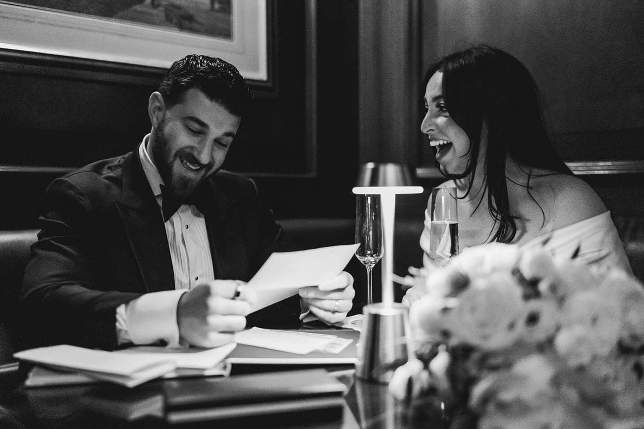 A documentary photograph of a bride and groom reading private vows at The Dark Bar before their wedding celebration at Mooo.... Seaport.