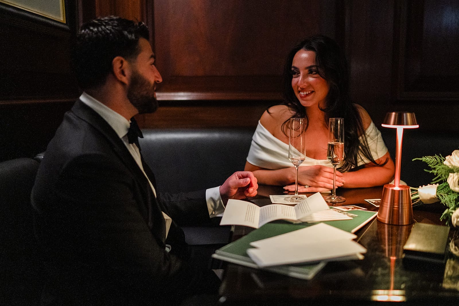 A documentary photograph of a bride and groom reading private vows at The Dark Bar before their intimate wedding at Mooo.... Seaport.